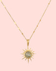 The 16" Labradorite North Star Necklace features a delicate chain and a sun-shaped pendant with a round, iridescent labradorite stone at the center.