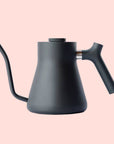 The Stagg Pour-Over Kettle (Stovetop) is a matte black kettle with a minimalist design, precision pour spout, and angled handle, shown against a plain white background.