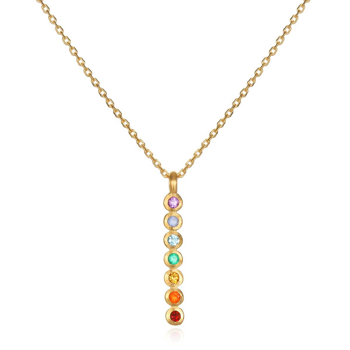 The Satya Jewelry Multi Stone Chakra Stick Necklace is an 18k gold-plated necklace with a vertical pendant featuring seven vibrant gemstones, each symbolizing a different chakra.