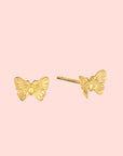 The Freedom to Soar Butterfly Stud Earrings, crafted with lustrous 18k gold plate, are shown on a white background from both front and side angles—ideal for anyone inspired by transformation-themed jewelry.