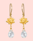 The Spiritual Journey Lotus Crystal Earring features gold-plated lotus flowers with clear teardrop crystal pendants, combining elegance and the charm of crystal healing jewelry, displayed against a white background.