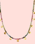 The Tourmaline Gold Moon Choker Necklace features multicolored pink, green, and blue tourmaline beads with round gold charms evenly spaced along the lower half.