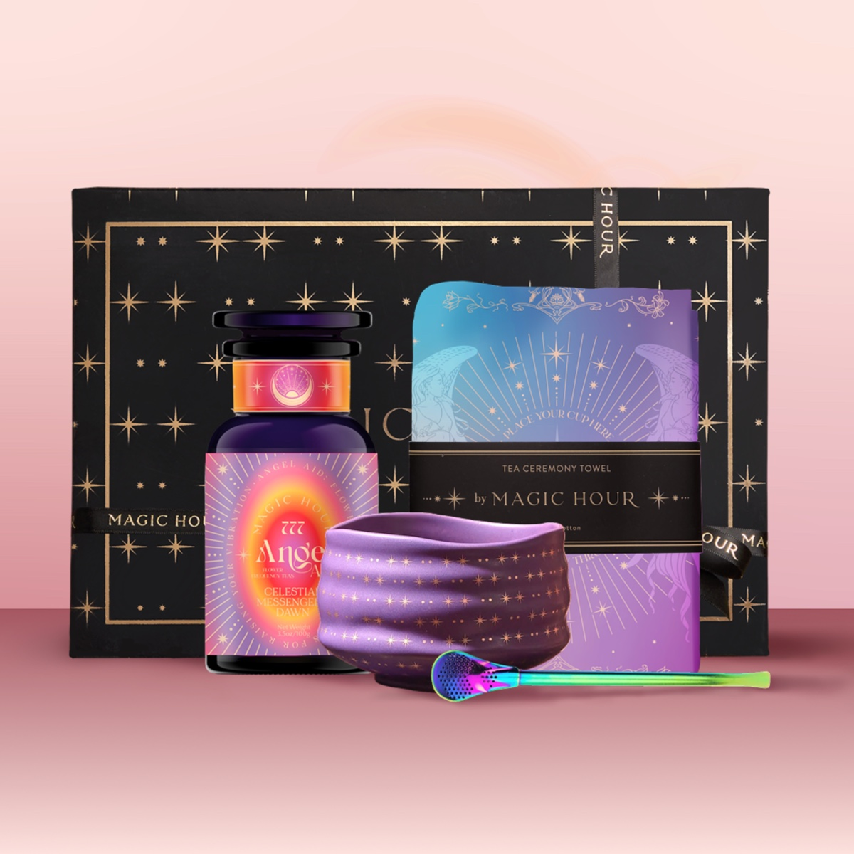 The Angel Numerology Fruit & Flower Tea Gift Set includes a starry black box, “Angelic” crystal tea jar, radiant teacup, vibrant tea towel, and colorful scoop—all artfully displayed on a soft pink background.