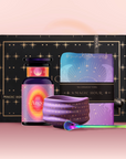 The Angel Numerology Fruit & Flower Tea Gift Set includes a starry black box, “Angelic” crystal tea jar, radiant teacup, vibrant tea towel, and colorful scoop—all artfully displayed on a soft pink background.
