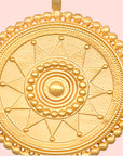 The 18" Sunburst Medallion Necklace features a round gold plated pendant with geometric patterns, including concentric circles, triangles, and beaded detailing on the outer edge.