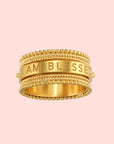 The Satya Jewelry Blessings Mantra Spinning Ring, plated in 18KT gold, features beaded edges and the engraved mantra "I AM BLESSED" on its smooth center band. Available in sizes 6, 7, and 8.