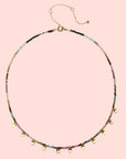 The Tourmaline Gold Moon Choker Necklace features a delicate gold-plated chain with multicolored round beads, seven gold disc charms, and an adjustable clasp—perfect for those seeking a subtle touch of elegance.