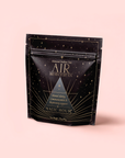 A black and gold resealable bag labeled "Air: Mint, Mullein & Citrus Tea for Respiratory Support" by Magic Hour, featuring star and line designs, with decaf green tea to support clarity, communication, and respiratory wellness.