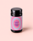 A black tea canister with a pink, blue, and gold label reading “Magic Hour 222: Hibiscus-Papaya Oolong with Roses,” set against a light pink background, invites you to experience a celestial rose blend tea.