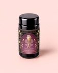 A canister of Aphrodite’s Alchemy: Damiana & Rose White Tea is adorned with an ornate, floral design and a golden, winged woman reminiscent of the Greek goddess of love, evoking the enchanting essence of Aphrodite.