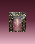 A beautifully designed tea package labeled "Aphrodite's Alchemy: Damiana & Rose White Tea," featuring an illustrated goddess of love from Greek mythology, surrounded by flowers and elegant gold accents.