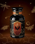 A black apothecary-style jar labeled “Candy Corn: Herbal Fall Tea with Vanilla & Caramel” sits on a brown background adorned with gold stars, a crescent moon, dragonflies, and moths—making this caffeine-free herbal blend the perfect cozy companion for crisp autumn nights.