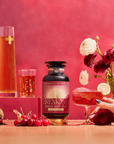 A bottle of Cherry Cola Black Tea: Ceremonial Soda Pop Tea with Sugar "Destroyer" is surrounded by cherries, flowers, a cocktail glass with a lime slice, a tall tea glass, and floating flowers on a pink background.