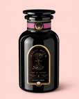 A black jar labeled “Magic Hour” with a gold design rests on a pink background. The label reads “Time for Infinity” and highlights “ceremonial petals” as well as “Child’s Pose™ Herbal Adaptogen Tea for Sleep Case Packs.” Crafted with organic ingredients, this herbal tea provides aromatherapeutic benefits perfect for relaxation and restful moments.