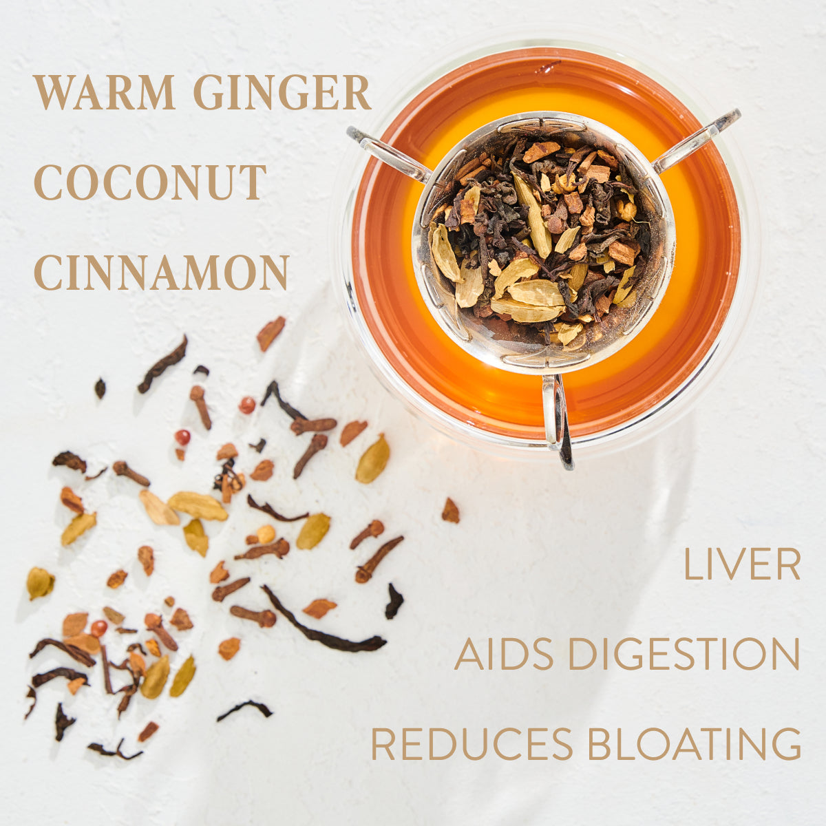 A cup of tea filled with assorted organic spices, viewed from above. Surrounding the cup on a white surface are scattered tea leaves and spice pieces. Text reads: "Warm Ginger Coconut Cinnamon. Liver. Aids Digestion. Reduces Bloating." Enjoy the richness of Zhena’s Original Coconut Chai Black Tea Refill Pouch in every sip!