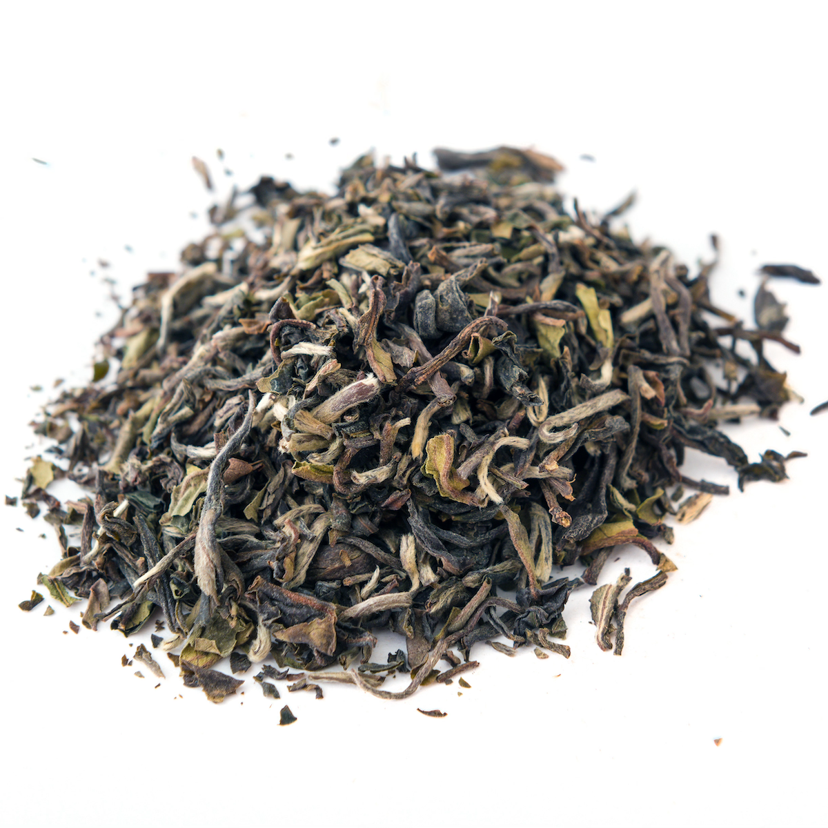 A close-up image of a pile of loose leaf tea from the renowned Goomtee Tea Estate on a white background. The Magic Hour April 2024 Harvest - Grand Cru First Flush Goomtee Estate Darjeeling FTGFOP1 leaves are a mix of green, brown, and dark shades, showcasing their varied textures and hues, reminiscent of a First Flush Darjeeling.