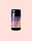 A black cylindrical container of Pitta: Caffeine-Free Saffron Tea for Balancing Body, Mind & Emotions with a purple and gold label sits on a pale pink background. This Ayurvedic blend helps soothe inflammation and restore balance.