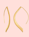 The Hammered Dot Petal Earrings are a pair of gold-plated lotus earrings that feature an elegant curved design with a beaded edge detail. These earrings have a sleek, long hook for wearing, and the beaded texture enhances their intricate and sophisticated appearance.