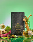 A black and gold tea package labeled "Earth: Stabilizing and Nourishing Herbs, Roots, and Puerh tea" rests among flowers, moss, driftwood, and a glass cup of grounding tea on a green gradient background.