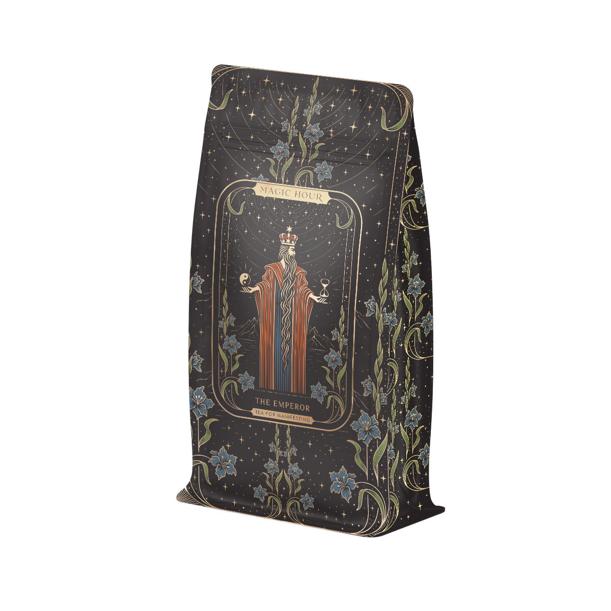 A decorated tea packaging features an illustration of a robed figure wearing a crown with "Magic Hour" at the top and "The Emperor" below. Inspired by Tarot archetypes, the background has an intricate pattern with floral elements and starry skies. This elegant design complements our Monthly Magic® First Sips Tea Subscription - Just the Tea!