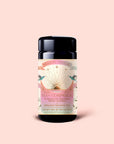 A jar of Magic Hour’s Tea for Compassion: Ti Quan Yin, adorned with a sunburst design and pastel hues, features illustrations of hands and plants. The label notes it’s an organic Oolong tea with 5 sachets, crafted in the traditional Ti Quan Yin style for a mindful sipping experience.