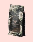 The "Goddess of Earl: Madagascar Vanilla Creme Tea" bag features gold and white floral patterns, elegant lettering, and a pale pink background—inviting you to enjoy soothing delight and delicious decadence in every dreamy bergamot vanilla cup.