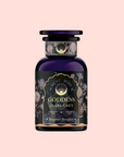 A dark blue glass jar with an ornate black and gold label reading "Goddess of Earl: Lady Luck Oriental Beauty Oolong Tea" sits against a light pink background, its elegant floral design hinting at tea notes of bergamot, grapefruit, and loose leaf oolong.
