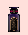 A dark purple, elegant bottle of Ruby Moon™: Hibiscus Elderberry Tea, adorned with gold accents and celestial motifs on a soft pink background, evokes the allure of a healing potion rich in vitamin C.