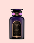 A dark purple glass bottle labeled “Magic Hour” with gold and black details, a round black lid, and celestial hourglass art holds Child’s Pose™ Herbal Adaptogen Tea Blend for Sleep & Restful Calm, set against a light pink background.