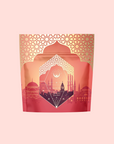 Turkish Delight, an aromatic caffeine-free herbal tea, comes in a decorative red and gold package with geometric patterns and a cityscape silhouette inspired by Istanbul architecture on a light pink background.