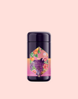 A dark purple cylindrical container of Pink Moment Pixie - Hibiscus Tangerine Dream Herbal Tea with a colorful label showing oranges, grapes, elderberry, and flowers on a light pink background.