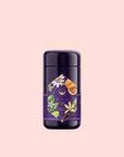 A dark purple cylindrical container labeled with botanical illustrations of flowers, leaves, and citrus, showcases Romance in Ravello Chocolate-Passionfruit-Rose-Cream White Tea, set against a light pink background.