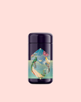 A dark, cylindrical container with a colorful label featuring birds and plants sits against a plain light pink background—inside is Tulum Horchata Chai, an energizing yerba mate and ashwagandha adaptogenic wellness potion.