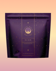 A purple and gold resealable pouch labeled "Magic Hour Bali Bliss" features celestial graphics on a pastel background, highlighting the Coconut-Lime & Ginger-Melon White Tea loose leaf blend.