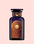 A dark purple glass bottle with a gold-embellished label featuring a sun, moon, and hands, labeled "Queen of the South Cocoa Detox Tea," a caffeine-free blend inspired by Café de Olla, set against a pale pink background.