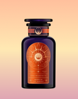 A dark purple glass bottle with an ornate orange celestial label reads "Queen of the Harvest: Herbal Relaxation Tea" and "Caffeine-Free Ashwagandha," set against a peach-to-yellow gradient background.