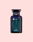 A luxurious, dark blue bottle of Aquamarine Dream - Soothing Herbal Ayurvedic Adrenal Tonic features a geometric aquamarine tea-inspired gemstone design and a round emblem on the neck, set against a pale pink background.