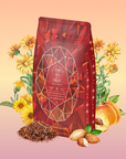 A red Carnelian: Caffeine-Free Apricot Amaretto Tea bag stands upright amid illustrated yellow flowers, peaches, almonds, and loose tea leaves—creating an inviting herbal scene on a warm peach background.