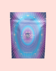 A vibrant sachet labeled "444: Sachiel's Prosperity: Apple-Berry Herbal Tea with Butterfly Pea Flower and Blue Spirulina," adorned with starburst and stars on a blue-purple gradient, set against a light pink background.
