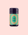 A dark bottle with a vibrant, ornate label reading "888: Lemon-Jasmine-Vanilla Herbal Tea" stands centered on a pale pink background. The orange, teal, and gold design evokes the bright abundance of citrus tea and Archangel Michael’s protection.
