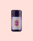 A purple cylindrical container labeled "111: Lavender-Jasmine-Pineapple Herbal Tea with Blue Lotus" sits on a pastel pink surface—ideal for crown chakra tea or blends featuring Egyptian blue lotus.