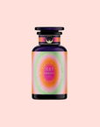 A bottle with a dark cap and base, featuring a pink, orange, and purple gradient label reading "333: Mango-Lemon Balm-Rose Herbal Tea with Passionflower," inspired by a floral fruit blend, set against a soft pink background.