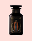 A dark glass bottle labeled "The Emperor: Green Chaga Chai with Lion's Mane and Reishi" features a tarot card-style crowned figure in red robes, gold details, and floral accents, inspired by immune support blends like mushroom tea.