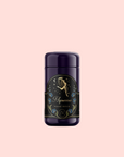 A dark purple cylinder labeled with an angel or fairy, blue flowers, and “Aquarius: Visionary Goddess Tea”—perfect for displaying vanilla black tea on a pale pink background.
