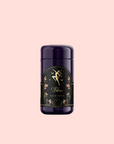 A dark purple deodorant stick labeled "Libra Shatavari-Cardamom-Rose White Love Cake Tea" with gold accents and floral designs, inspired by rose pistachio tea, displayed against a light pink background.