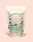 A pastel-hued pouch of Magic Hour's Tea for Calm: Mantra Mint: Mint With Rose & Vanilla Herbal Tea features floral and celestial artwork, labeled "Mint with Rose & Vanilla" and "Ceremonial Teas Made with Love." This soothing organic blend combines calming botanicals to create a serene tea experience in every cup.