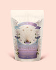 A pastel-colored Magic Hour tea package adorned with floral illustrations, butterflies, and a sunburst design. The label reads "Tea for Healing: Aquamarine Dream: Blueberries, Pineapple & Nervines Herbal Tea," highlighting details like "Butterfly Pea Flower" and "13 sachets." This adaptogenic tea blend is thoughtfully crafted to support restful sleep and gentle nervous system balance, making each cup a soothing ritual.