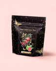 A black resealable pouch labeled “Guava Pomegranate Black Iced Tea” features guava, pomegranate, and butterflies on a starry background—perfect for fans of organic black tea and fruity blends.