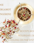 A glass teapot filled with hot water and dried tea leaves, including rose petals, is displayed alongside loose leaf tea on a light surface. Text on the image reads: "Rose, Bergamot, Tangerine. Boosts Mood, Nourishes Skin, Cooling on the System." Indulge in this organic Magic Hour Harmonize White Tea experience.