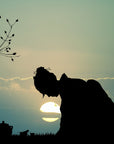 Silhouette of a person in traditional clothing bowing with the setting sun behind them. To the left, a branch with leaves extends into the scene, while a teapot and cup filled with Jasmine Moon White Tea from Magic Hour are positioned on the ground on the right side of the image.
